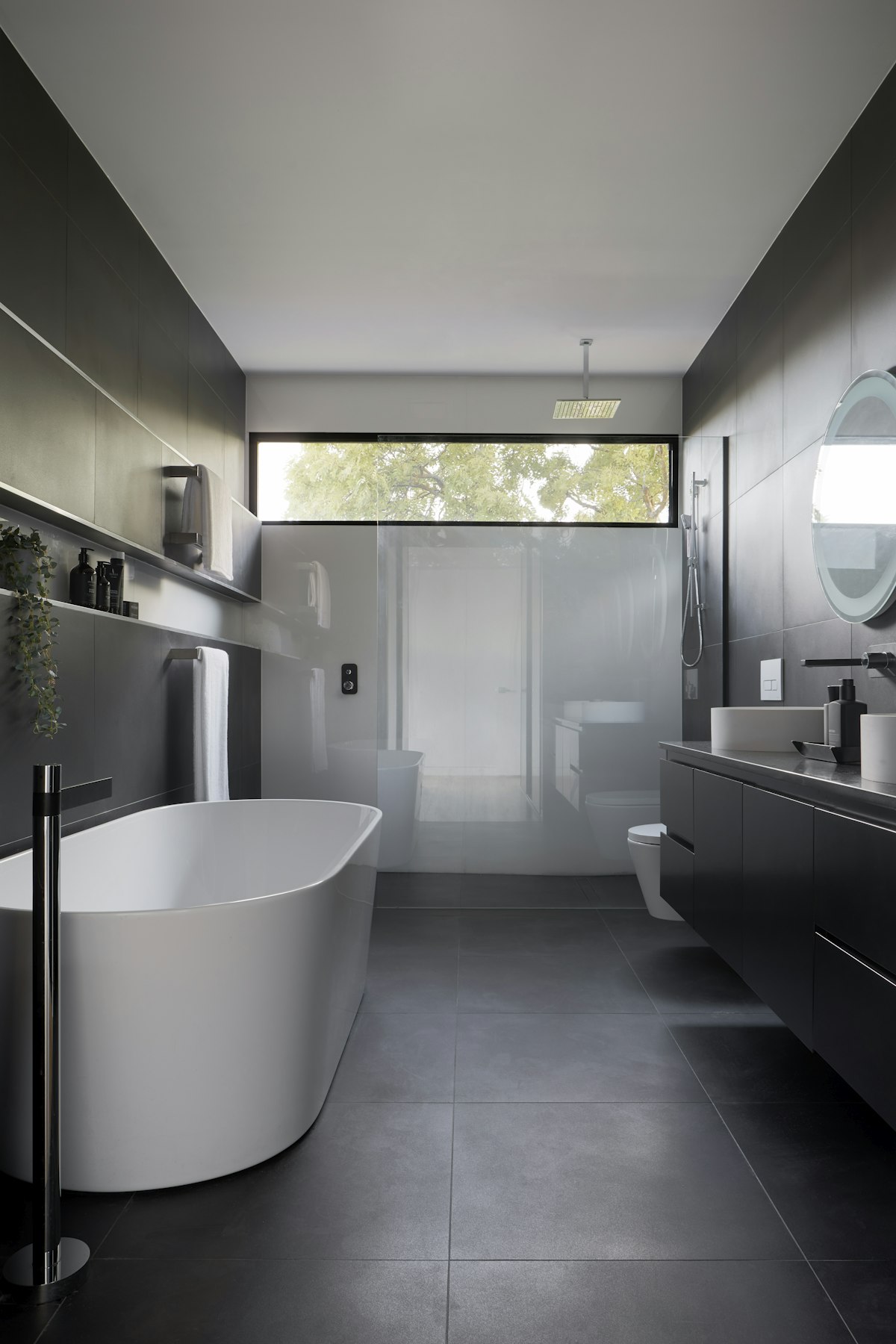 Modern master bathroom with freestanding soaking tub and seamless walk-in shower.