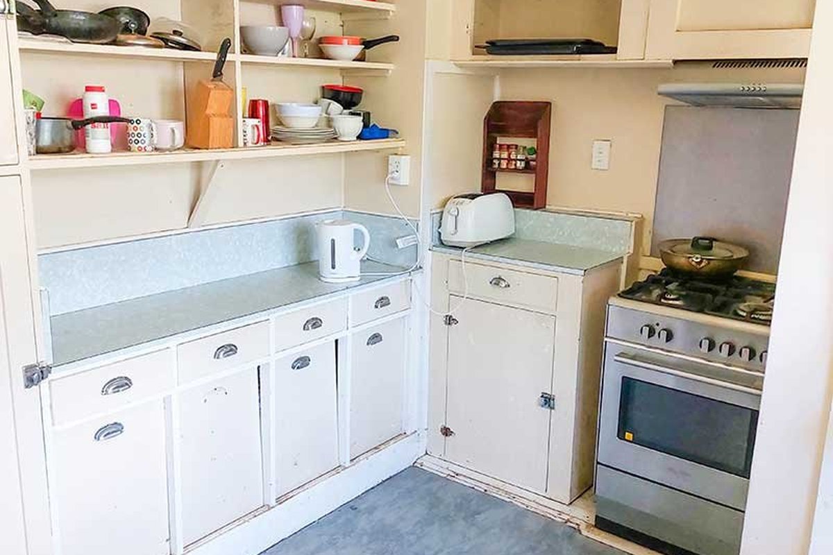 Before remodel: Dark enclosed kitchen with dividing wall blocking the living room in Chula Vista.